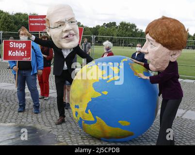 Berlin, DEUI, 03.07.2020 - Umweltaktivisten tragen Masken von Bundeskanzlerin Angela Merkel und Bundeswirtschaftsminister Peter Altmaier während einer Protestaktion von Campact gegen das Kohlegesetz im Reichstag in Berlin. Bundestag und Bundesrat verabschieden Gesetze zum Ausstieg aus der Kohle in Deutschland, die bis 2038 abgeschlossen sein sollen. [Automatisierte Übersetzung] Stockfoto