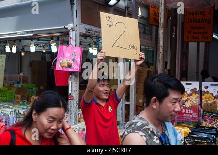 24. Januar 2020, Singapur, Republik Singapur, Asien - Ein Verkäufer hält zu Beginn der Corona-Krise ein Pappschild mit einem Sparangebot hoch, während die Menschen durch einen belebten Straßenbasar im Chinatown-Viertel der Stadt schlendern, der jährlich zum chinesischen Neujahr stattfindet. Kurz nachdem der Stadtstaat seine erste Infektion mit dem Coronavirus bestätigt hatte (Covid-19). [Automatisierte Übersetzung] Stockfoto