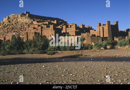 10.11.2010, Ouarzazate, Marokko, Afrika - Blick auf die Architektur der alten Lehmbauten der historischen Festung Aït-Ben-Haddouh im Abendlicht, ein UNESCO-Weltkulturerbe entlang der ehemaligen Karawanenstraße zwischen der Sahara und Marrakesch. Der Ort diente als Kulisse für zahlreiche Filmproduktionen, von Lawrence von Arabien über James Bond bis hin zu Game of Thrones. Im Vordergrund sieht man das schmale Flusstal des Asif Mellah. [Automatisierte Übersetzung] Stockfoto