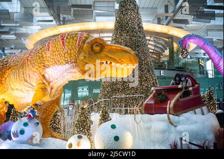08. Dezember 2020, Singapur, Republik Singapur, Asien - Dinosaurier, Ein Schlitten und ein Weihnachtsbaum dienen im Dino Wanderland als Weihnachtsdekoration und Fotoruckentwürfe für Besucher und Flugreisende in der Abfluglounge im Terminal 3 des Changi International Airport inmitten der globalen Coronavirus-Pandemie (Covid-19). [Automatisierte Übersetzung] Stockfoto