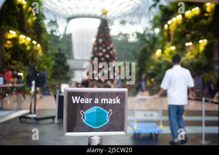 08. Dezember 2020, Singapur, Republik Singapur, Asien - Ein Schild (trägt eine Maske) warnt die Menschen am Eingang zum neuen Juwelenterminal am Changi International Airport, dass Masken obligatorisch sind, um eine weitere Ausbreitung des Coronavirus (Covid-19) während der globalen Corona-Pandemie zu verhindern. [Automatisierte Übersetzung] Stockfoto