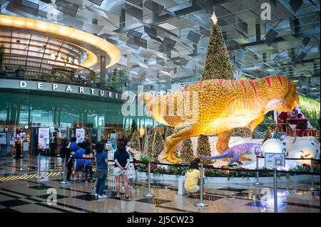 08. Dezember 2020, Singapur, Republik Singapur, Asien - Dinosaurier, Ein Schlitten und ein Weihnachtsbaum dienen im Dino Wanderland als Weihnachtsdekoration und Fotoruckentwürfe für Besucher und Flugreisende in der Abfluglounge im Terminal 3 des Changi International Airport inmitten der globalen Coronavirus-Pandemie (Covid-19). [Automatisierte Übersetzung] Stockfoto