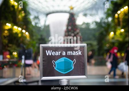 08. Dezember 2020, Singapur, Republik Singapur, Asien - Ein Schild (trägt eine Maske) warnt die Menschen am Eingang zum neuen Juwelenterminal am Changi International Airport, dass Masken obligatorisch sind, um eine weitere Ausbreitung des Coronavirus (Covid-19) während der globalen Corona-Pandemie zu verhindern. [Automatisierte Übersetzung] Stockfoto
