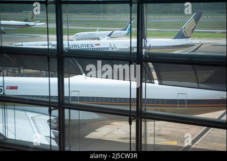 08. Dezember 2020, Singapur, Republik Singapur, Asien - Ein Passagierflugzeug, das von der Tochtergesellschaft Silk Air von Singapore Airlines betrieben wird, wird an geparkten Flugzeugen vorbei zum Terminalbereich des Changi International Airport geschleppt. Aufgrund der weltweiten Ausbreitung des Coronavirus (Covid-19) wurde der weltweite Flugverkehr drastisch reduziert und es kommt weiterhin zu erheblichen Flugausfällen. SIA betreibt derzeit nur einen Bruchteil seines Streckennetzes, während die meisten Flugzeuge weiterhin am Boden arbeiten. Die Behörden von Singapur und Hongkong haben bereits Vorkehrungen für eine Quarantänefreiheit zwischen den beiden getroffen Stockfoto