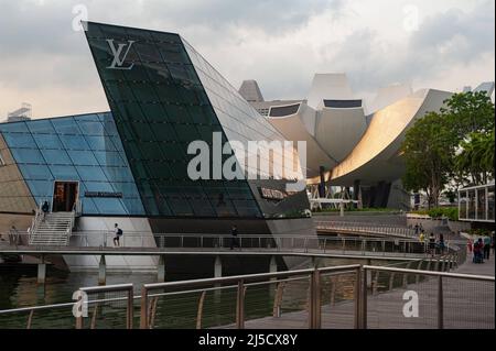 12.04.2019, Singapur, Republik Singapur, Asien - Waterfront in Marina Bay mit den modernen Louis Vuitton Island Maison Crystal Pavilions und dem ArtScience Museum im Hintergrund. Beide Bauten wurden vom Architekturbüro Safdie Architects entworfen. [Automatisierte Übersetzung] Stockfoto