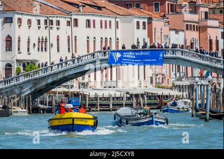 Arbeitsboote transportieren Müll (in ukrainischer Farbe) und Güter auf dem Canale Grande - die Kanäle sind die Hauptarterien für alle Formen des Wassertransports - Venedig zu Beginn der Biennale di Venezia im Jahr 2022. Stockfoto