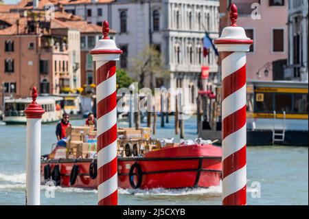 Arbeitsboote transportieren Müll und Güter auf dem Canale Grande - die Kanäle sind die Hauptarterien für alle Formen des Wasserverkehrs - Venedig zu Beginn der Biennale di Venezia im Jahr 2022. Stockfoto