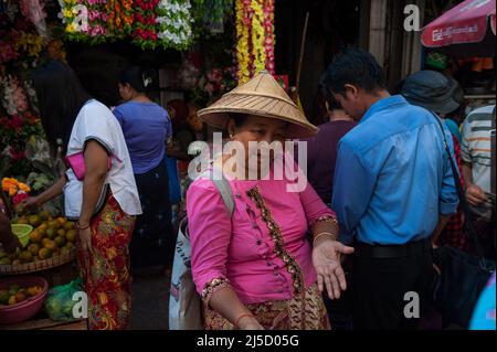 27. Januar 2017, Yangon, Republik der Union von Myanmar, Asien - Eine Frau mit einem traditionellen Bambushut kauft auf einem Straßenmarkt im Stadtzentrum der ehemaligen Hauptstadt Yangon Lebensmittel ein. [Automatisierte Übersetzung] Stockfoto