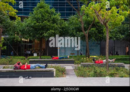 26. Oktober 2018, Singapur, Republik Singapur, Asien - Eine Gruppe südasiatischer Wanderarbeiter ruhen nach der Arbeit auf Bänken im Geschäfts- und Finanzviertel von Marina Bay. [Automatisierte Übersetzung] Stockfoto