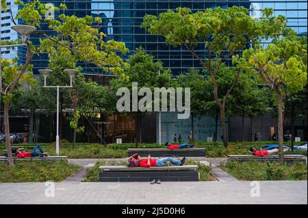 26. Oktober 2018, Singapur, Republik Singapur, Asien - Eine Gruppe südasiatischer Wanderarbeiter ruhen nach der Arbeit auf Bänken im Geschäfts- und Finanzviertel von Marina Bay. [Automatisierte Übersetzung] Stockfoto