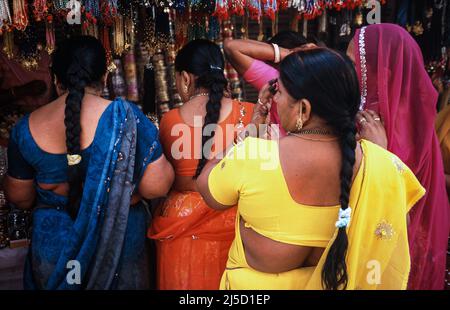 13.03.2010, Haridwar, Uttarakhand, Indien, Asien - Frauen in ihren bunten traditionellen Kleidern stehen während des hinduistischen religiösen Festivals Purna Kumbh Mela vor einem Straßenstand. [Automatisierte Übersetzung] Stockfoto