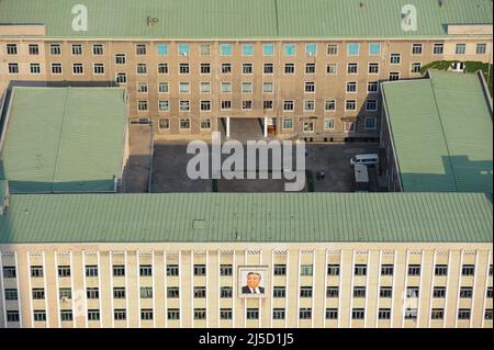 08.08.2012, Pjoengjang, Nordkorea, Asien - Blick von der Aussichtsplattform des Chuche-Turms auf ein Büro- und Verwaltungsgebäude im Stadtzentrum der nordkoreanischen Hauptstadt. An der Gebäudefassade ist ein Bild des ehemaligen Führers Kim Il Sung angebracht. [Automatisierte Übersetzung] Stockfoto