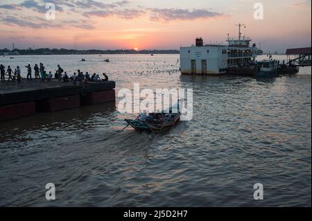 26. Januar 2017, Yangon, Myanmar, Asien - Flusskabinen und Passagierfähren befahren lokale Pendler über den Yangon-Fluss (Hlaing River) zwischen einem Yangon-Steg und der Stadt Dala (Dalah) am Südufer, mit der untergehenden Abendsonne im Hintergrund. [Automatisierte Übersetzung] Stockfoto