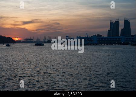 02.10.2016, Singapur, Republik Singapur, Asien - Blick vom Sentosa Boardwalk auf die untergehende Sonne über Harbourfront und Keppel Bay mit dem Containerhafen Pasir Panjang Terminal in der Ferne. [Automatisierte Übersetzung] Stockfoto