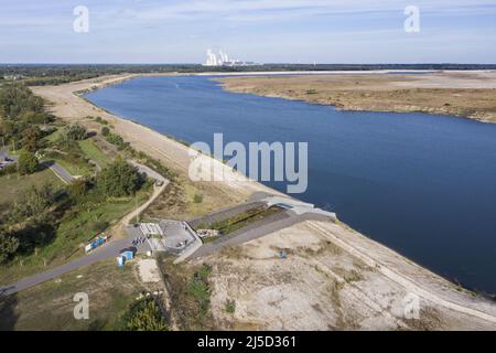 Lakoma, 02.10.2021 - Blick von der Ostsee auf das Braunkohlekraftwerk Jaenschwalde der LEAG Lausitz Energie Kraftwerke AG. Der Cottbus Ostsee ist ein Projekt, bei dem die ehemalige Braunkohlemine Cottbus-Nord mit Wasser aus der Spree überflutet wird. [Automatisierte Übersetzung] Stockfoto