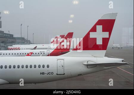 14. Dezember 2021, Zürich, Schweiz, Europa - die Passagierflugzeuge von Swiss Airlines und Helvetic Airways parken auf ihren Standplätzen am Flughafen Zürich. Swiss ist Mitglied der Luftfahrtallianz Star Alliance, einem internationalen Netzwerk von Fluggesellschaften. [Automatisierte Übersetzung] Stockfoto