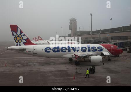 14. Dez. 2021, Zürich, Schweiz, Europa - ein Passagierflugzeug des Typs Airbus A320 von der Firma Airbus mit Registrierung HB-IJV parkt an einem nebligen Morgen am Terminal A des Flughafens Zürich. Die Schweizer Charterfluggesellschaft, die ihren Hauptsitz in Kloten hat und ihren Sitz am Flughafen Zürich hat, hat ihren Sitz. Die Fluggesellschaft ist eine Tochtergesellschaft der Lufthansa und Schwestergesellschaft von Swiss International Air Lines. [Automatisierte Übersetzung] Stockfoto