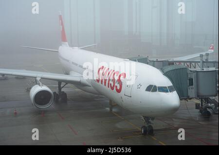 14. Dezember 2021, Zürich, Schweiz, Europa - an einem nebligen Morgen parkt ein Airbus A330-300, ein Passagierflugzeug von Swiss International Air Lines, am Dock E-Terminal am Flughafen Zürich in einer Standposition. Swiss ist Mitglied der Luftfahrtallianz Star Alliance, einem internationalen Netzwerk von Fluggesellschaften. [Automatisierte Übersetzung] Stockfoto