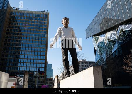 '03/12/2022, Berlin, Deutschland, Europa - die Skulptur ''Balanceakt'' ist ein Werk des deutschen Bildhauers Stephan Balkenhol und steht vor dem Axel Springer Wolkenkratzer und dem Neubau an der Ecke Axel-Springer-Straße und Zimmerstraße im Berliner Bezirk Kreuzberg. Die Arbeit besteht aus einem Mann mit schwarzer Hose und einem weißen Hemd, der auf einem Stück der Berliner Mauer balanciert, sowie elf Originalteilen der Mauer, die um die Figur platziert sind. Das Denkmal soll an die deutsche Wiedervereinigung und insbesondere den Fall der Mauer erinnern. [Automatisierte Übersetzung]' Stockfoto