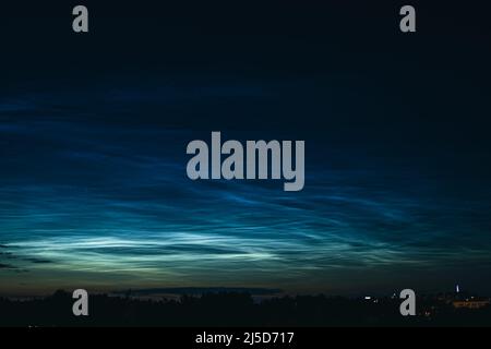 Nächtliche mesosphärische Wolken am Nachthimmel. Seltenes atmosphärisches Phänomen über der Stadt. Astronomie und Meteorologie. Stockfoto