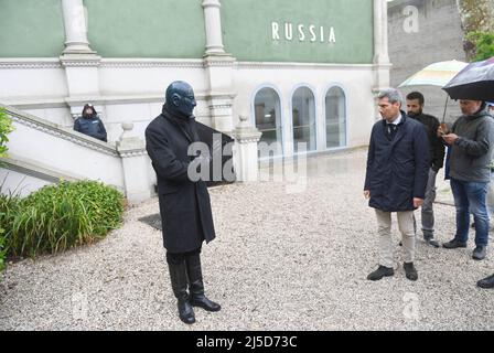 Venedig, Italien. 22. April 2022. Der maskierte ukrainische Schauspieler Alexey Judnikov gibt vor der Kunstbiennale 59. ein Interview während einer Performance vor dem russischen Pavillon. Kulturschaffende haben vor Ort gegen den Krieg in der Ukraine protestiert. Quelle: Felix Hörhager/dpa/Alamy Live News Stockfoto