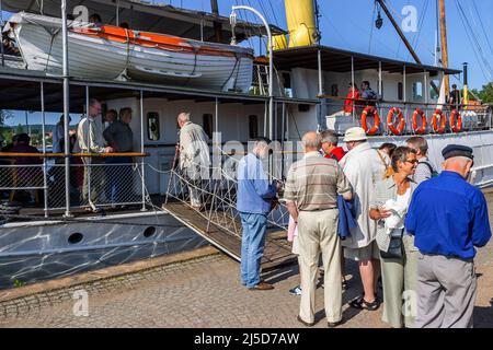 Menschen, die Schlange stehen, um an Bord eines alten Dampfschiffs im Hafen von Hjo, Schweden, zu gehen Stockfoto