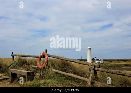 Walney Island, Cumbria, Großbritannien. 22.. April 2022. Wetter in Großbritannien. Trübe Sonne vom South Walney Nature Reserve. Blick von der Cumbrian Coast zum Walney Lighthouse. Kredit:greenburn/Alamy Live Nachrichten. Stockfoto