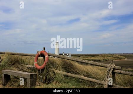 Walney Island, Cumbria, Großbritannien. 22.. April 2022. Wetter in Großbritannien. Trübe Sonne vom South Walney Nature Reserve. Blick von der Cumbrian Coast zum Walney Lighthouse. Kredit:greenburn/Alamy Live Nachrichten. Stockfoto