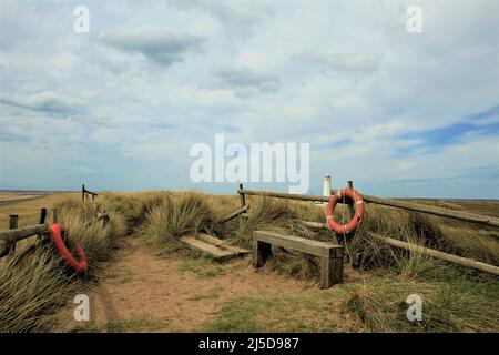 Walney Island, Cumbria, Großbritannien. 22.. April 2022. Wetter in Großbritannien. Trübe Sonne vom South Walney Nature Reserve. Blick von der Cumbrian Coast zum Walney Lighthouse. Kredit:greenburn/Alamy Live Nachrichten. Stockfoto