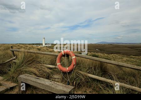 Walney Island, Cumbria, Großbritannien. 22.. April 2022. Wetter in Großbritannien. Trübe Sonne vom South Walney Nature Reserve. Blick von der Cumbrian Coast zum Walney Lighthouse. Kredit:greenburn/Alamy Live Nachrichten. Stockfoto