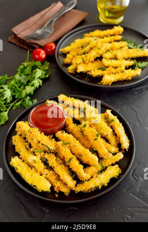 Gebratene Zucchini-Sticks und Tomatensauce auf dem Teller Stockfoto