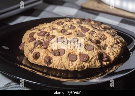 Großer Plätzchen mit Schokoladentropfen mit natürlichem Licht, hausgemachtes Rezeptkonzept. Stockfoto