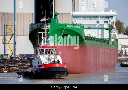 Leer, Deutschland. 22. April 2022. Der Massengutfrachter „Nordic Crystal“ wird nach seinem Start von einem Schlepper vor der Ferus Smit Werft geschleppt. Das Schiff wurde von der Werft für die schwedische Thun-Gruppe gebaut und ist etwa 100 Meter lang und 13,35 Meter breit. Quelle: Hauke-Christian Dittrich/dpa/Alamy Live News Stockfoto