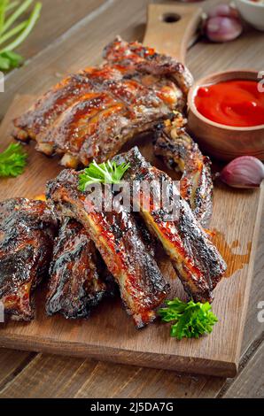 Würzige, heiß gegrillte Spare Ribs auf Schneidebrett Stockfoto