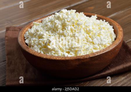 Hausgemachter Quark in Holzschüssel auf dem Tisch, Nahaufnahme Stockfoto