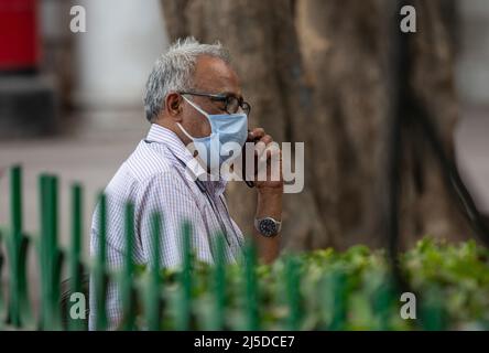 Neu-Delhi, Indien. 22. April 2022. Ein Mann mit Gesichtsmaske spricht auf einem Marktplatz in Neu-Delhi, Indien, am 22. April 2022 am Telefon. Indiens COVID-19-Zahlen stiegen am Freitag auf 43.052.425, da in den letzten 24 Stunden im ganzen Land 2.451 neue Fälle registriert wurden, zeigten die neuesten Daten des Bundesgesundheitsministeriums. Quelle: Javed Dar/Xinhua/Alamy Live News Stockfoto