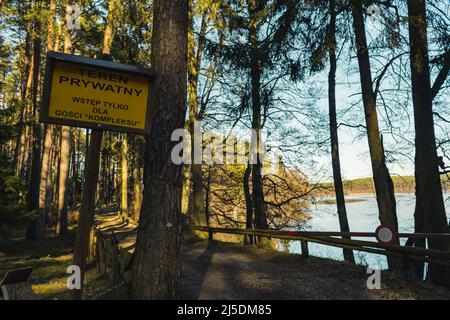 Wodden-Schild mit schriftlichem Eingang in das Hotel ist verboten, Gäste sind nur erlaubt. Hohes Brett im Wald neben einem See. Schild in dunkler Stirn Stockfoto