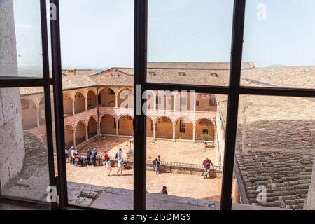 Interner Kreuzgang der Basilika des Heiligen Franziskus von Assisi. Innenhof mit Brunnen in der Kirche von San Francesco in Assisi, Umbrien, Italien. Stockfoto