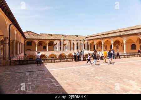 Interner Kreuzgang der Basilika des Heiligen Franziskus von Assisi. Innenhof mit Brunnen in der Kirche von San Francesco in Assisi, Umbrien, Italien. Stockfoto