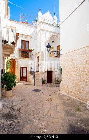 Eine typische schmale Straße in Locorotondo, die oft mit Blumen geschmückt ist, Apulien, Italien Stockfoto