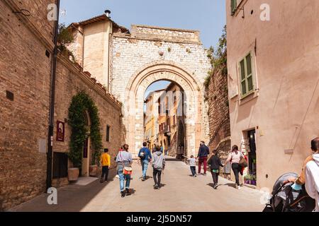 Die Menschen gehen durch die Straßen der kleinen Stadt Assisi, Umbrien, Italien. Touristen und Pilger in Assisi Stadt San Francesco und der Basilika. Stockfoto