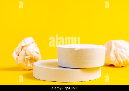 Weiße leere runde Podien mit Plattform zur Produktpräsentation auf hellgelbem Hintergrund. Minimale geometrische leere Bühnendekoration als Vorlage f Stockfoto