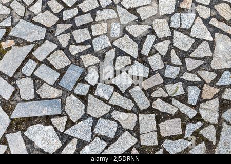 Granitsteinpflaster mit zufällig geformten Fragmenten, Draufsicht, Kopfsteinpflaster Hintergrund Foto Textur Stockfoto