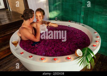 Valentinstag junges Paar im Whirlpool liegen romantische Badezimmer in den Flitterwochen Stockfoto
