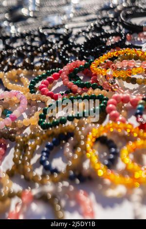 Hintergrund vieler Armbänder aus verschiedenen Steinen Stockfoto