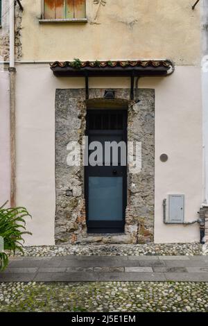 Außenansicht eines alten Hauses renoviert Erhaltung eines Teils der freiliegenden Steinmauer um die Haustür, Sanremo, Imperia, Ligurien, Italien Stockfoto