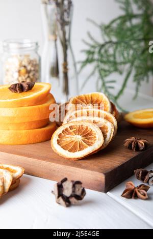 Getrocknete Orangenscheiben, Zimt und Sternanise auf Holzbrett. Stockfoto