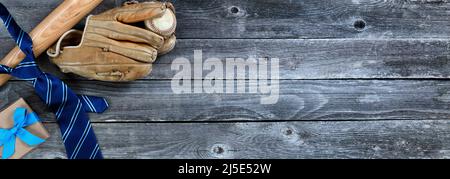 Blaue Krawatte, Baseballausrüstung und eine Geschenkbox auf einem Vintage-Holztisch für das Patres Day-Konzept Stockfoto