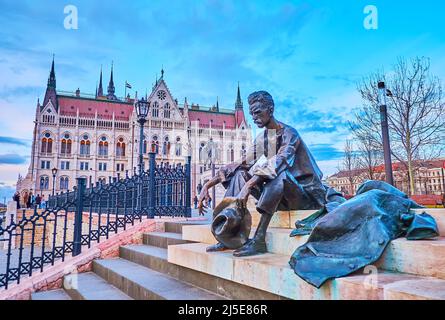 Die Statue von Jozsef Attila, die auf der Treppe des ungarischen Parlamentsgebäudes von Budapest, Ungarn, sitzt Stockfoto