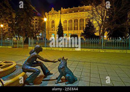 Genießen Sie den Abendspaziergang in Pest mit Blick auf das Mädchen mit ihrer Hundeskulptur am Vigado-Platz, Budapest, Ungarn Stockfoto
